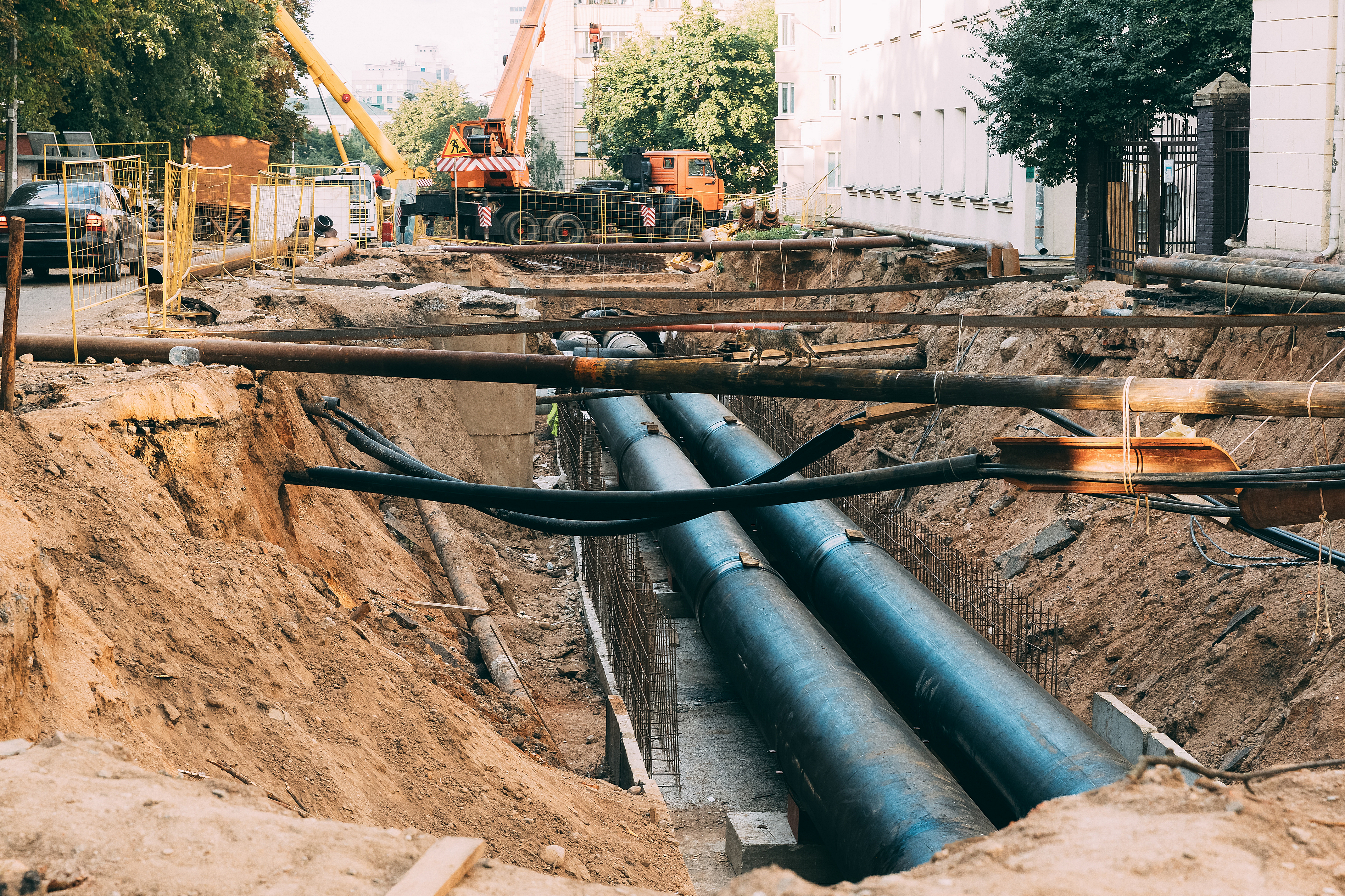 Large steel pipes being installed in urban roadway for pipe ramming utility crossing